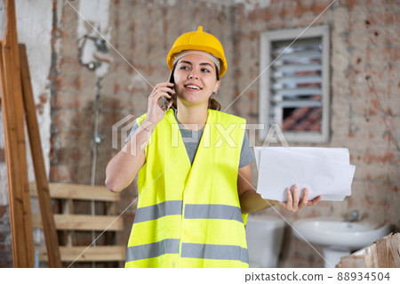 Woman talking on phone at building site Woman talking on phone at building site 88934504
