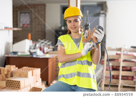 Female builder posing on indoor construction site 88934559