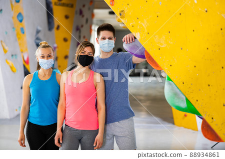 Group photo of women and young man in masks standing in climbing gym Group photo of women and young man in masks standing in climbing gym 88934861