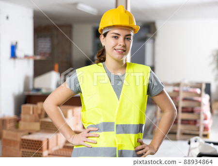 Portrait of positive woman builder standing in construction site 88934864