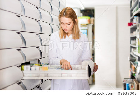 Female pharmacist offers medicine in a modern pharmacy 88935003