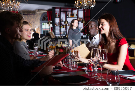 Happy people having dinner at fashionable restaurant and drinking wine 88935097