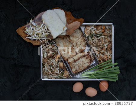 Stir fried soft turnip cake or Fried radish cake (chai tow kway) with bean sprout and chives. Thai - Chinese food called Kanom Pak kad or Char Koay Kak, Selective focus. 88935757