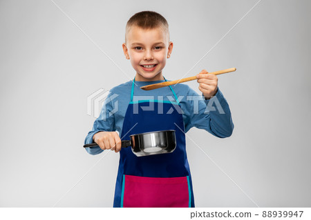 little boy in apron with saucepan cooking food 88939947