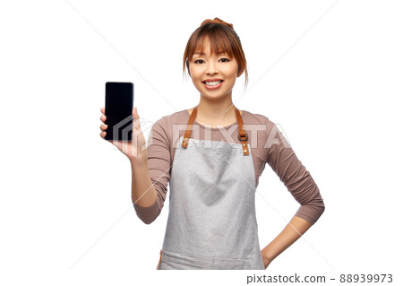 happy woman in apron showing smartphone happy woman in apron showing smartphone 88939973