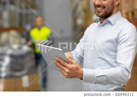 happy businessman with tablet pc at warehouse happy businessman with tablet pc at warehouse 88940311
