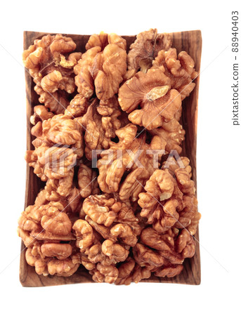 Walnuts in wooden dish isolated on white. Walnuts in wooden dish isolated on white. 88940403