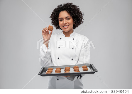 happy female chef with cookies on oven tray happy female chef with cookies on oven tray 88940404