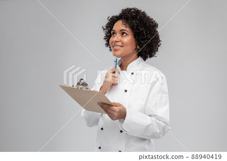smiling female chef with clipboard and pen smiling female chef with clipboard and pen 88940419