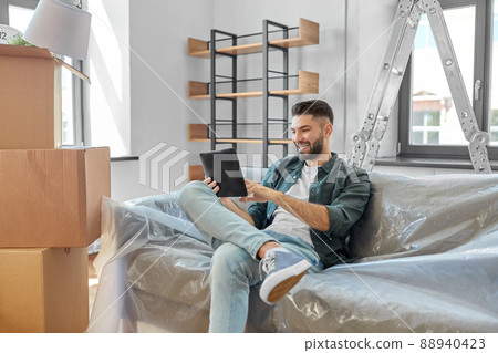 man with tablet pc and boxes moving into new home 88940423