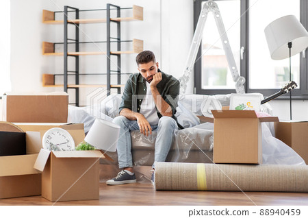 sad man with boxes moving to new home sad man with boxes moving to new home 88940459