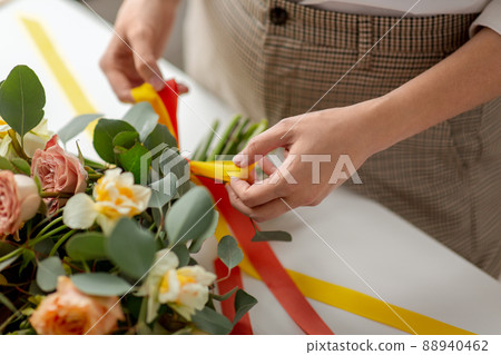 close up of woman making bunch of flowers on table close up of woman making bunch of flowers on table 88940462