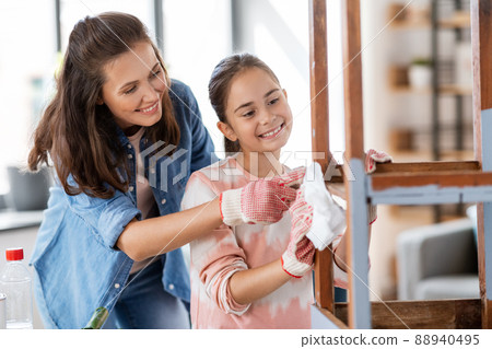 mother and daughter cleaning old table with tissue 88940495