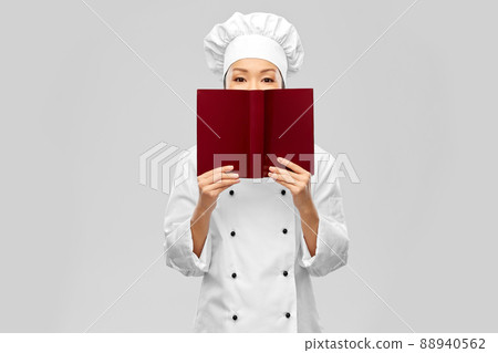 female chef hiding behind cook book female chef hiding behind cook book 88940562