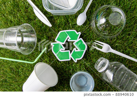 green recycling sign and plastic waste on grass 88940610