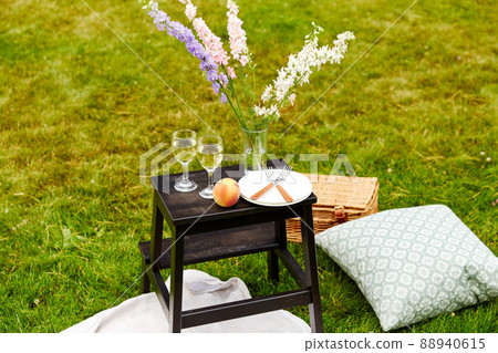 picnic basket, flowers and wine glasses at park picnic basket, flowers and wine glasses at park 88940615
