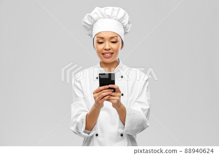 smiling female chef with smartphone smiling female chef with smartphone 88940624