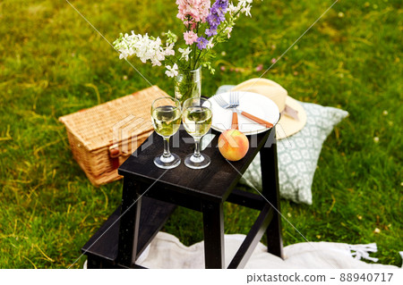 picnic basket, flowers and wine glasses at park picnic basket, flowers and wine glasses at park 88940717
