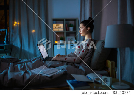 teenage girl with laptop learning in bed at night teenage girl with laptop learning in bed at night 88940725