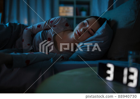 awake teenage girl lying at home at night awake teenage girl lying at home at night 88940730