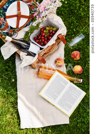 picnic basket, food, drinks and book on grass picnic basket, food, drinks and book on grass 88940739