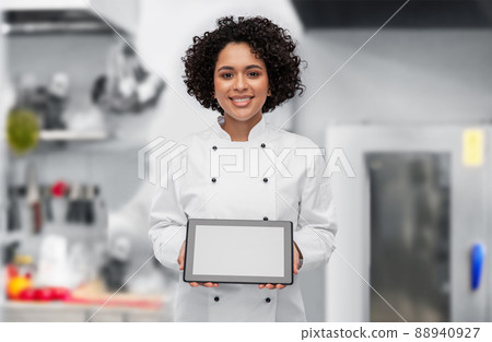 smiling female chef showing tablet pc on kitchen 88940927