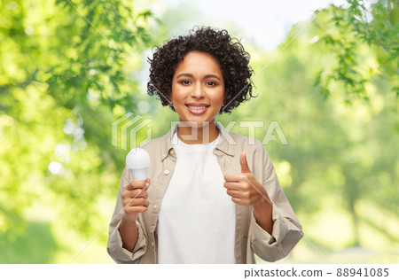 happy smiling woman holding lighting bulb happy smiling woman holding lighting bulb 88941085