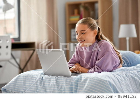 smiling girl with laptop computer at home 88941152