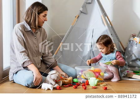mother and daughter playing tea party at home mother and daughter playing tea party at home 88941172