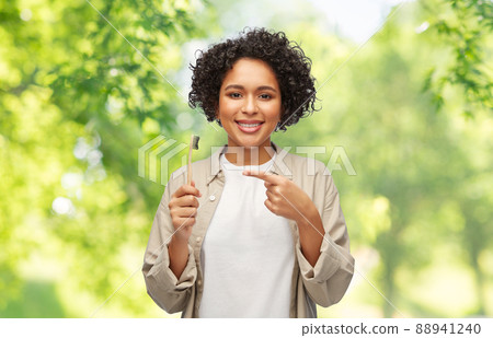 smiling woman holding wooden toothbrush 88941240