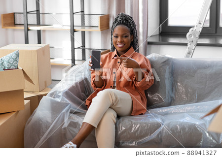 woman with smartphone and boxes moving to new home 88941327