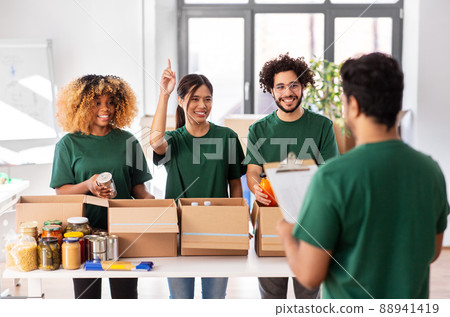 happy volunteers packing food in donation boxes 88941419