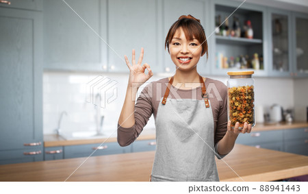 woman in apron with pasta in jar showing ok sign woman in apron with pasta in jar showing ok sign 88941443