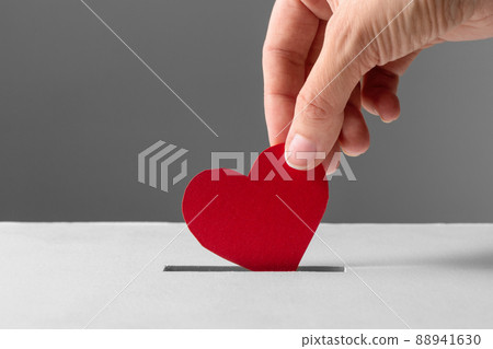 hand putting red heart into donation box hand putting red heart into donation box 88941630