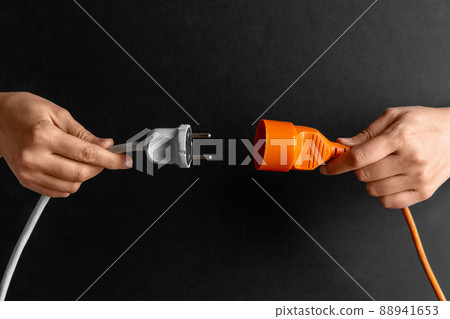 close up of woman inserting plug into socket 88941653
