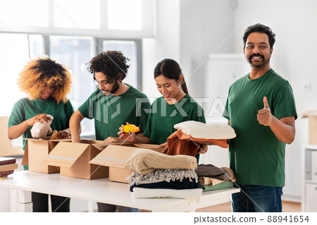 volunteers packing stuff and showing thumbs up 88941654