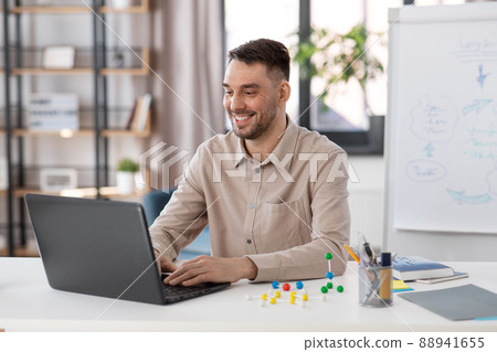 smiling male teacher with laptop working at home 88941655