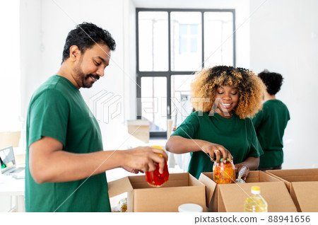 happy volunteers packing food in donation boxes 88941656