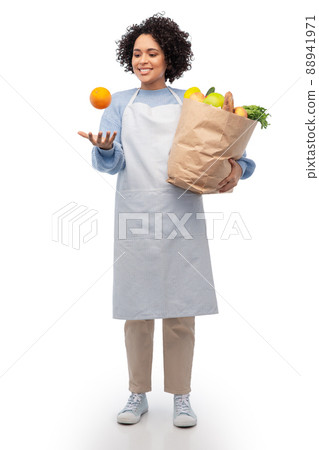 woman in apron with takeaway food in paper bag woman in apron with takeaway food in paper bag 88941971