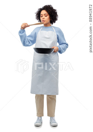 woman in apron with frying pan tasting food woman in apron with frying pan tasting food 88941972
