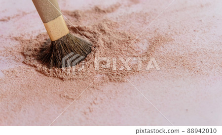 Closeup of a make-up brush, with the tip dipped into a pile of brown cosmetic foundation powder. Closeup of a make-up brush, with the tip dipped into a pile of brown cosmetic foundation powder. 88942010