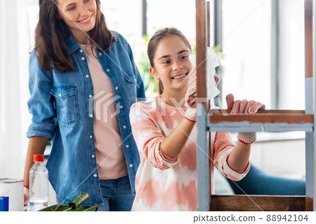 mother and daughter cleaning old wooden table mother and daughter cleaning old wooden table 88942104