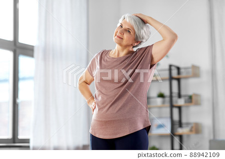 smiling senior woman exercising at home smiling senior woman exercising at home 88942109