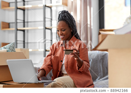 woman with laptop and credit card at new home 88942166