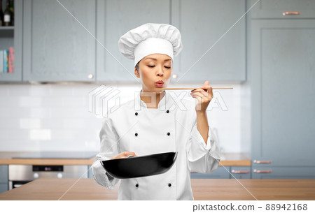 female chef with frying pan tasting food female chef with frying pan tasting food 88942168
