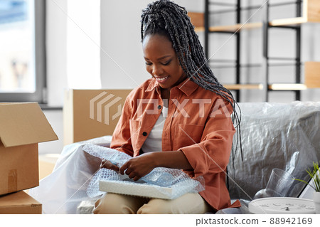 happy woman packing boxes and moving to new home 88942169