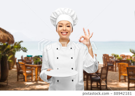female chef holding empty plate and showing ok female chef holding empty plate and showing ok 88942181