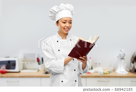 smiling female chef reading cook book smiling female chef reading cook book 88942185