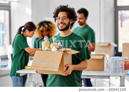 happy volunteers packing food in donation boxes happy volunteers packing food in donation boxes 88942189