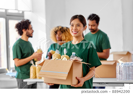 happy volunteers packing food in donation boxes 88942200